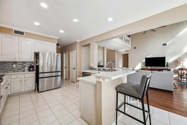 3919 Park Circle Way, Houston, TX 77059 - kitchen featuring stainless steel appliances, light tile patterned floors, a kitchen breakfast bar, a peninsula, and ornamental molding