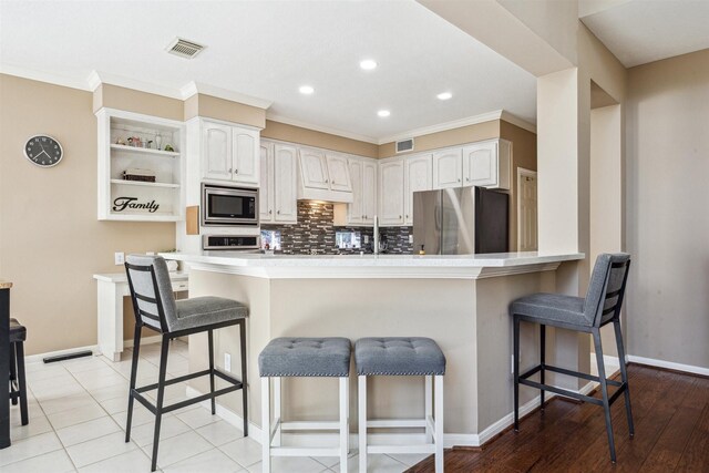 3919 Park Circle Way, Houston, TX 77059 - kitchen with stainless steel appliances, open shelves, a breakfast bar area, a peninsula, and recessed lighting