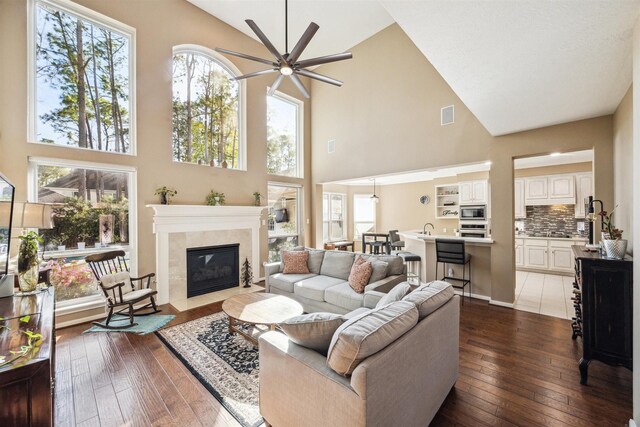 3919 Park Circle Way, Houston, TX 77059 - living room featuring high vaulted ceiling, ceiling fan, a fireplace, dark wood-type flooring, and plenty of natural light