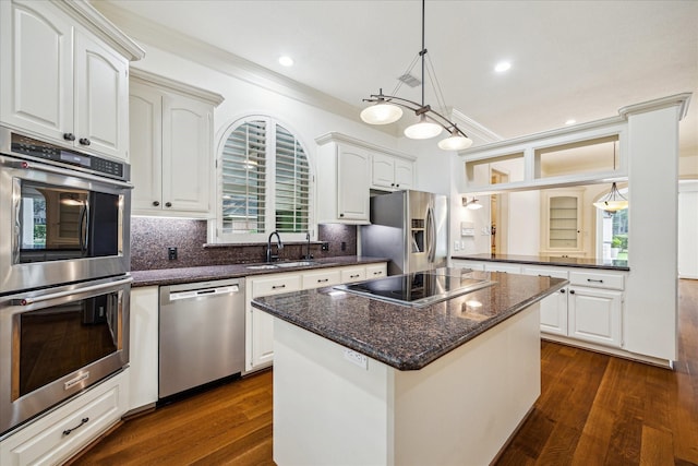 30 Halfmoon Ct, The Woodlands, TX 77380 - kitchen featuring appliances with stainless steel finishes, dark wood-style floors, ornamental molding, a center island, and decorative backsplash