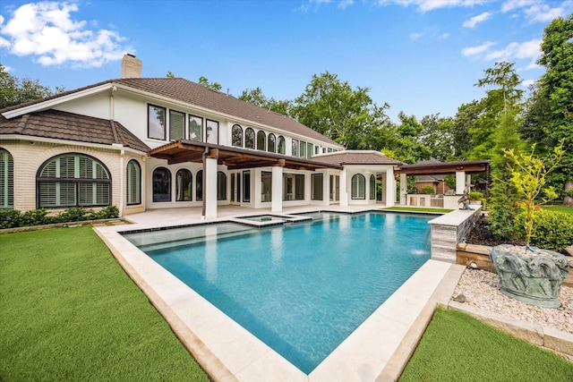 30 Halfmoon Ct, The Woodlands, TX 77380 - back of property featuring a chimney, a pool with connected hot tub, a lawn, a patio area, and stucco siding