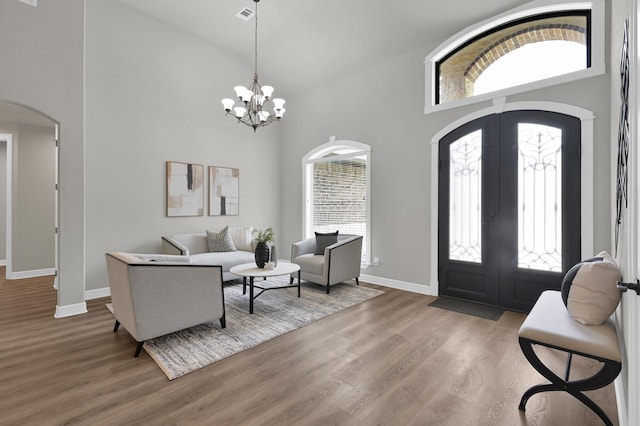 2172 Greentree Dr, Huntsville, TX 77340 - entrance foyer featuring arched walkways, high vaulted ceiling, french doors, a chandelier, and wood finished floors