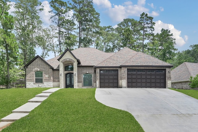 2172 Greentree Dr, Huntsville, TX 77340 - french country inspired facade featuring brick siding, a garage, driveway, a front yard, and a shingled roof