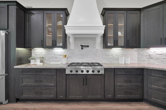 2172 Greentree Dr, Huntsville, TX 77340 - kitchen with appliances with stainless steel finishes, custom exhaust hood, backsplash, dark wood-type flooring, and glass insert cabinets