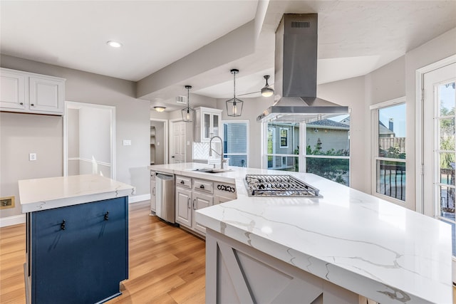 1526 Pecan Crossing Dr, Richmond, TX 77406 - kitchen with extractor fan, stainless steel gas cooktop, light wood-style floors, a center island, and white cabinets