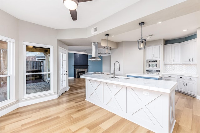 1526 Pecan Crossing Dr, Richmond, TX 77406 - kitchen featuring a kitchen island with sink, light wood-style flooring, white cabinetry, a ceiling fan, and recessed lighting