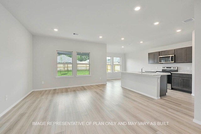 217 Rockbridge Dr, Huntsville, TX 77340 - kitchen with stainless steel appliances, light wood finished floors, recessed lighting, open floor plan, and light countertops