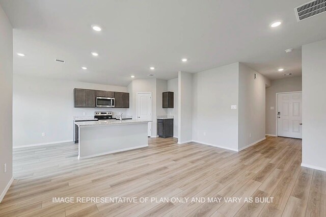 217 Rockbridge Dr, Huntsville, TX 77340 - kitchen featuring stainless steel appliances, open floor plan, light wood-style flooring, light countertops, and recessed lighting