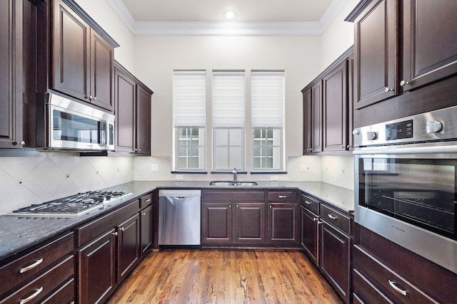 1048 W 21st St, Houston, TX 77008 - kitchen with appliances with stainless steel finishes, decorative backsplash, light wood-type flooring, crown molding, and dark brown cabinets