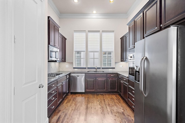 1048 W 21st St, Houston, TX 77008 - kitchen with appliances with stainless steel finishes, ornamental molding, dark brown cabinets, light wood-style flooring, and recessed lighting