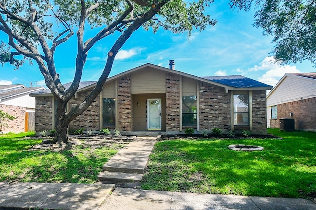 14511 Lourdes Dr, Houston, TX 77049 - mid-century inspired home featuring brick siding, a front lawn, and a fire pit