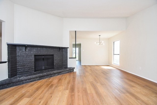 14511 Lourdes Dr, Houston, TX 77049 - unfurnished living room featuring wood finished floors, a chandelier, and a fireplace