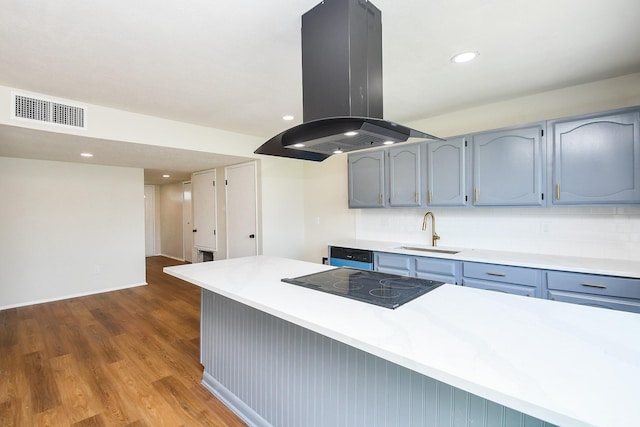 14511 Lourdes Dr, Houston, TX 77049 - kitchen with island exhaust hood, black electric cooktop, wood finished floors, light countertops, and recessed lighting