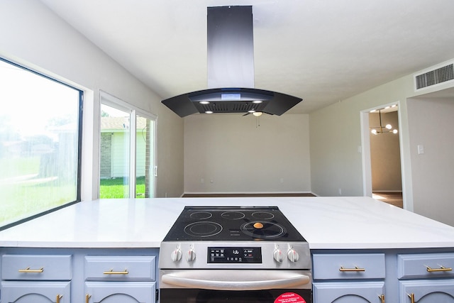 14511 Lourdes Dr, Houston, TX 77049 - kitchen with electric range, island exhaust hood, light countertops, and gray cabinets