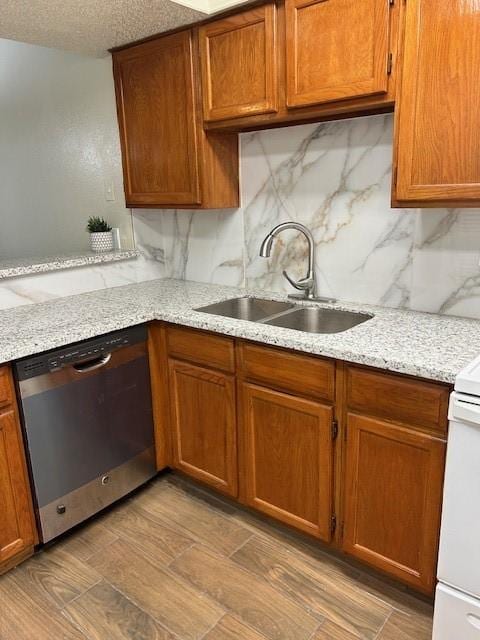 10555 Turtlewood Ct Unit 2111, Houston, TX 77072 - kitchen with stainless steel dishwasher, tasteful backsplash, brown cabinetry, light stone counters, and a textured ceiling