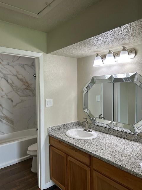 10555 Turtlewood Ct Unit 2111, Houston, TX 77072 - bathroom with vanity, wood finished floors, washtub / shower combination, and a textured ceiling