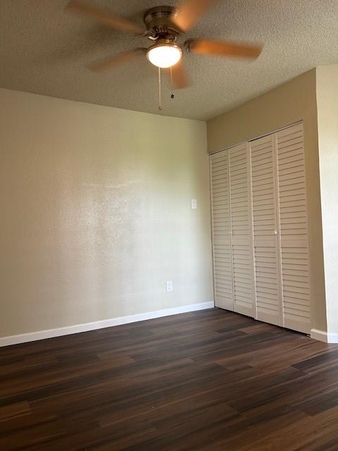 10555 Turtlewood Ct Unit 2111, Houston, TX 77072 - unfurnished bedroom with dark wood-style floors, a closet, and ceiling fan