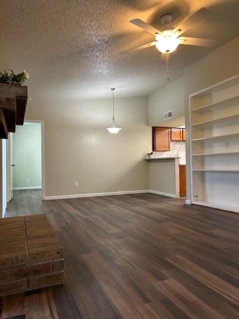 10555 Turtlewood Ct Unit 2111, Houston, TX 77072 - unfurnished living room featuring ceiling fan, dark wood-type flooring, and a textured ceiling