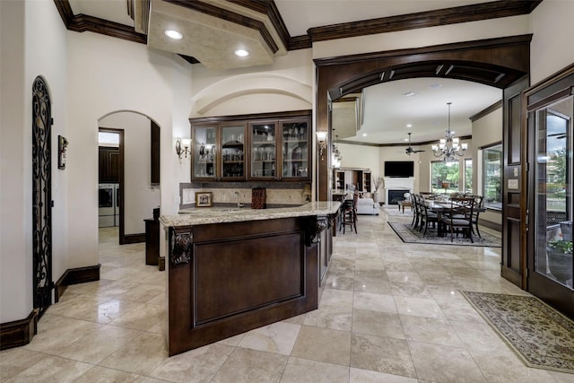 7507 Emerald Meadow Ct, Katy, TX 77494 - bar featuring arched walkways, separate washer and dryer, crown molding, a chandelier, and recessed lighting