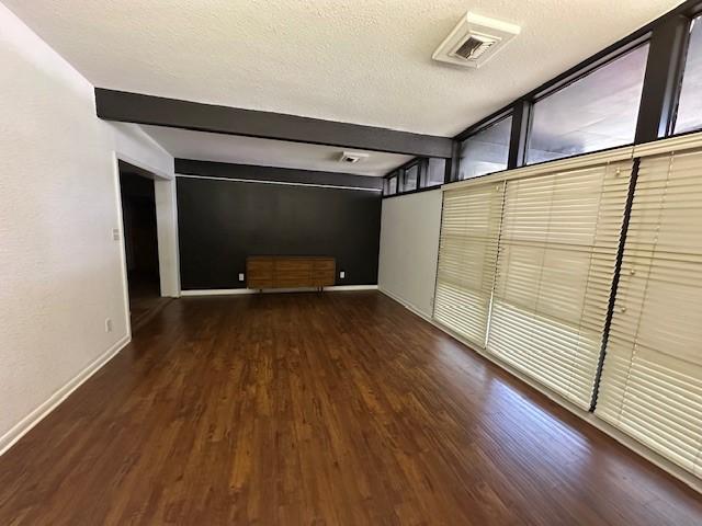 3900 Aggie Dr, Bay City, TX 77414 - unfurnished room featuring wood finished floors, a textured ceiling, and beamed ceiling