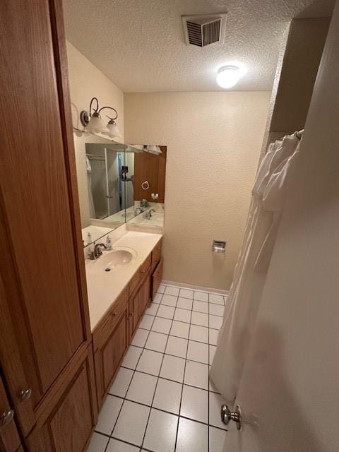 3900 Aggie Dr, Bay City, TX 77414 - full bath featuring vanity, a textured ceiling, tile patterned flooring, and a shower