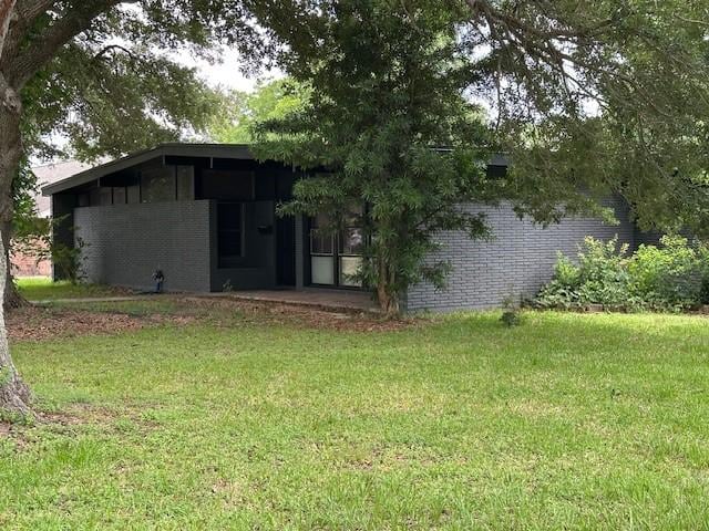 3900 Aggie Dr, Bay City, TX 77414 - view of side of property featuring a lawn and brick siding