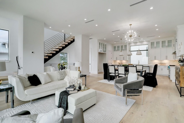 1022 Allston St, Houston, TX 77008 - living area featuring plenty of natural light, stairway, light wood finished floors, recessed lighting, and a chandelier