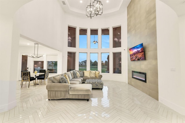 19303 Tree Canopy Ct, Cypress, TX 77433 - living area featuring a chandelier, a tiled fireplace, a high ceiling, arched walkways, and recessed lighting