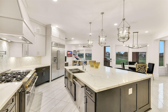 19303 Tree Canopy Ct, Cypress, TX 77433 - kitchen featuring premium appliances, light tile patterned flooring, tasteful backsplash, recessed lighting, and a chandelier