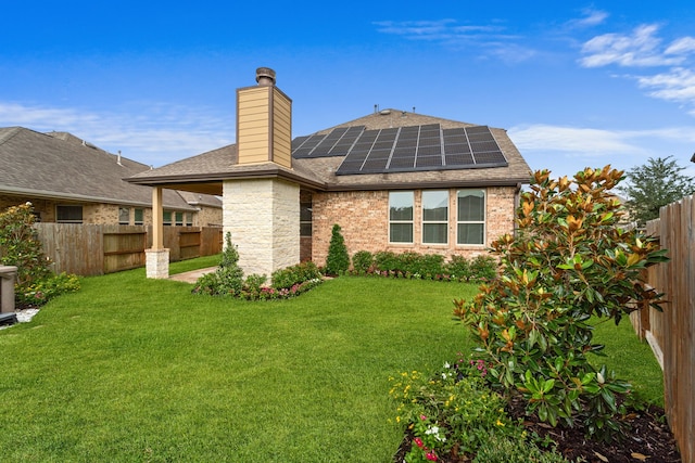 16746 Highland Country Dr, Cypress, TX 77433 - rear view of house with a shingled roof, roof mounted solar panels, a fenced backyard, and a chimney