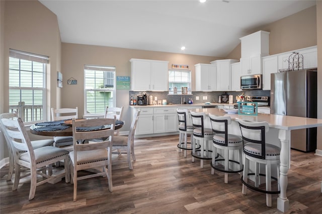 975 S S Cv, Crystal Beach, TX 77650 - kitchen with stainless steel appliances, a center island, vaulted ceiling, light countertops, and backsplash