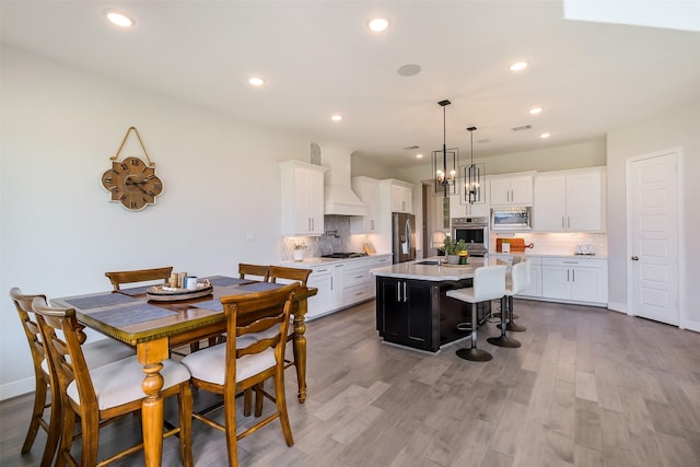 19506 Bradford Pines Ct, Cypress, TX 77433 - kitchen with stainless steel appliances, custom exhaust hood, light countertops, an island with sink, and a kitchen bar