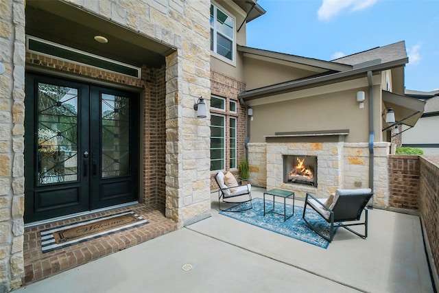 19506 Bradford Pines Ct, Cypress, TX 77433 - doorway to property with french doors, an outdoor stone fireplace, stone siding, stucco siding, and a patio