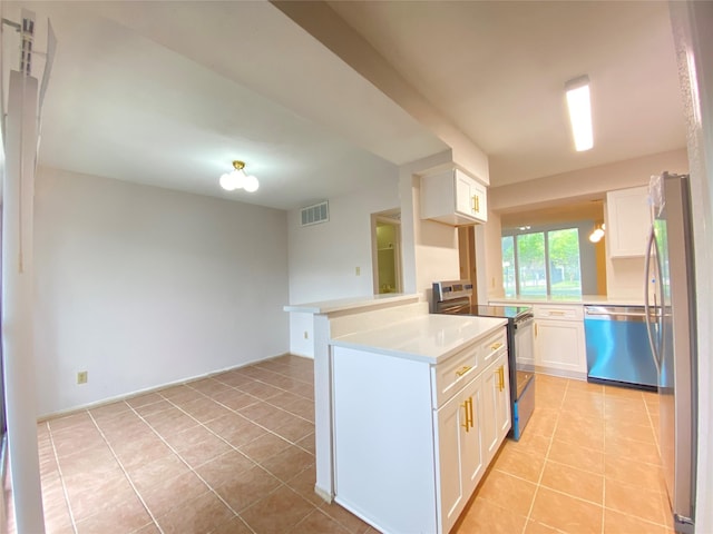 2601 S Braeswood Blvd Unit 605, Houston, TX 77025 - kitchen with appliances with stainless steel finishes, light tile patterned floors, white cabinets, light countertops, and a peninsula