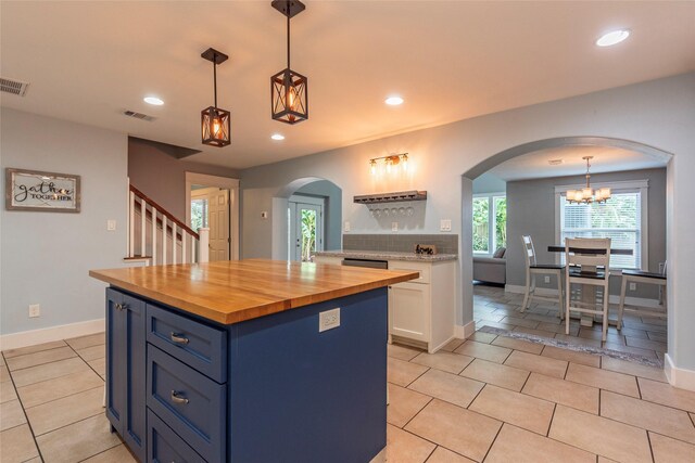 1017 Forest Rd, Clear Lake Shores, TX 77565 - kitchen with wooden counters, arched walkways, light tile patterned floors, recessed lighting, and white cabinetry
