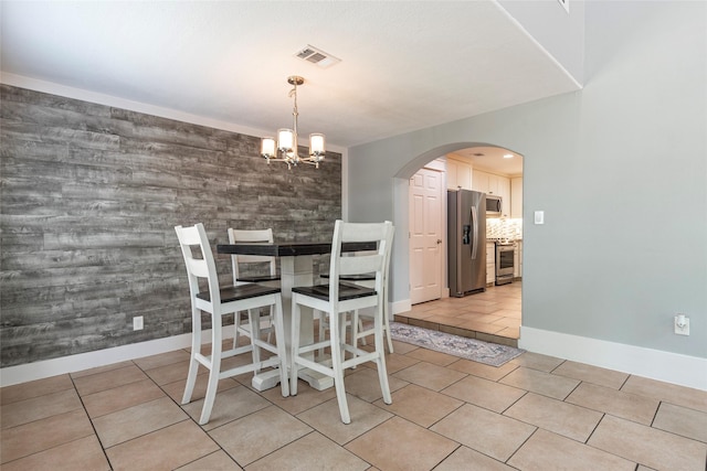 1017 Forest Rd, Clear Lake Shores, TX 77565 - dining room featuring arched walkways, a chandelier, and light tile patterned floors