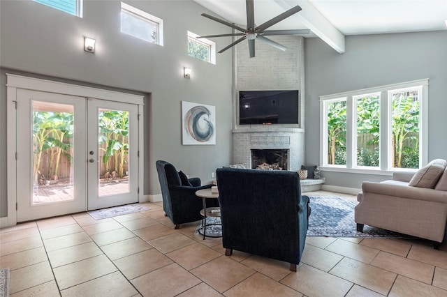1017 Forest Rd, Clear Lake Shores, TX 77565 - living room featuring beam ceiling, ceiling fan, light tile patterned floors, a brick fireplace, and a high ceiling