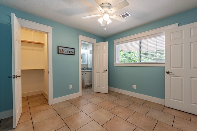 1017 Forest Rd, Clear Lake Shores, TX 77565 - unfurnished bedroom with light tile patterned flooring, a walk in closet, a closet, and ceiling fan