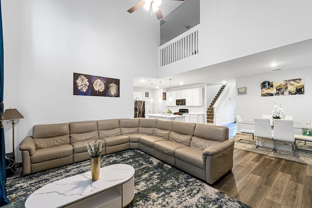 8619 Flamingo Bay Ln, Cypress, TX 77433 - living room with dark wood finished floors, stairs, a ceiling fan, recessed lighting, and a towering ceiling