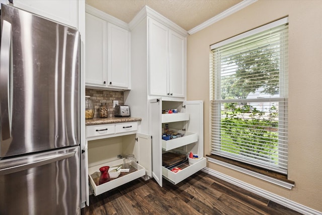 3214 Churchill St, Pearland, TX 77581 - kitchen with freestanding refrigerator, crown molding, dark wood-style flooring, white cabinetry, and decorative backsplash