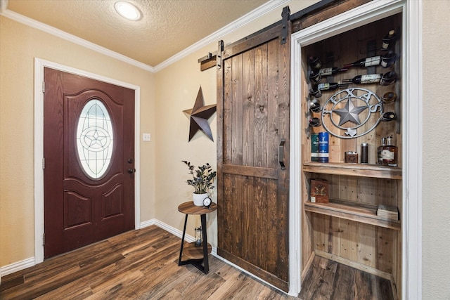 3214 Churchill St, Pearland, TX 77581 - entryway with wood finished floors, a textured ceiling, a barn door, and ornamental molding