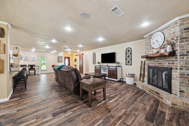 3214 Churchill St, Pearland, TX 77581 - living area with a textured ceiling, dark wood finished floors, ornamental molding, a brick fireplace, and recessed lighting