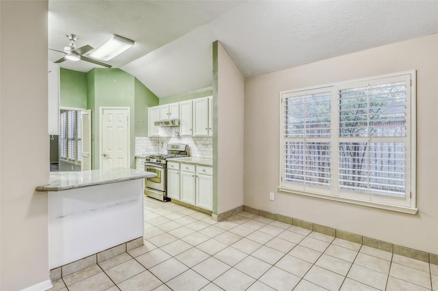 7215 Pembrough Ln, Katy, TX 77494 - kitchen with stainless steel gas stove, white cabinetry, ceiling fan, vaulted ceiling, and decorative backsplash