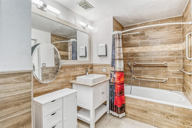 7215 Pembrough Ln, Katy, TX 77494 - full bathroom with tiled shower / bath, tile walls, vanity, tile patterned floors, and wainscoting