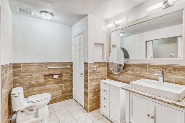 7215 Pembrough Ln, Katy, TX 77494 - bathroom featuring tile walls, vanity, tile patterned flooring, and a wainscoted wall