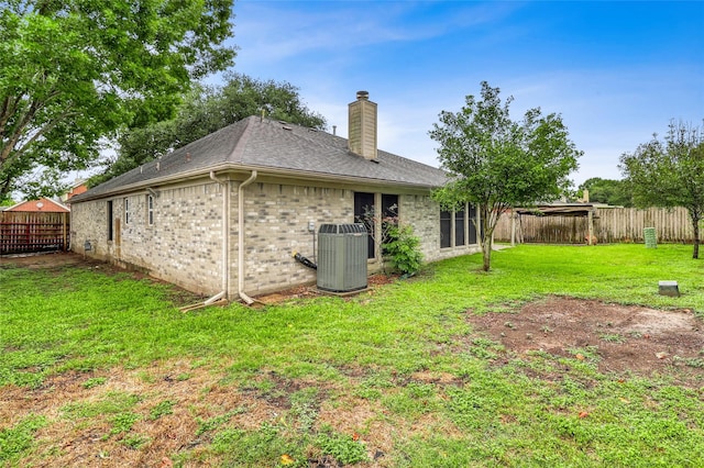 7215 Pembrough Ln, Katy, TX 77494 - rear view of house featuring a chimney, a fenced backyard, roof with shingles, and brick siding