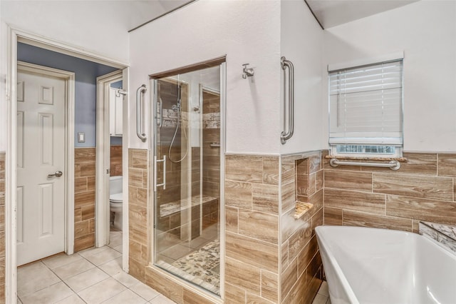 7215 Pembrough Ln, Katy, TX 77494 - full bath featuring tile walls, a wainscoted wall, tile patterned flooring, a freestanding bath, and a stall shower