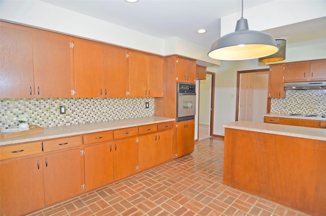 823 Timber Cove Dr, Seabrook, TX 77586 - kitchen featuring oven, under cabinet range hood, light countertops, brick patterned floors, and tasteful backsplash