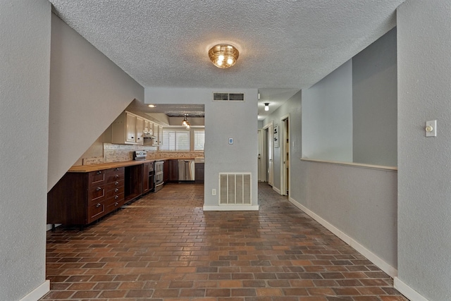 1437 Bowsprit Pt, Willis, TX 77318 - kitchen with dishwasher, brick flooring, light countertops, a textured ceiling, and dark brown cabinets