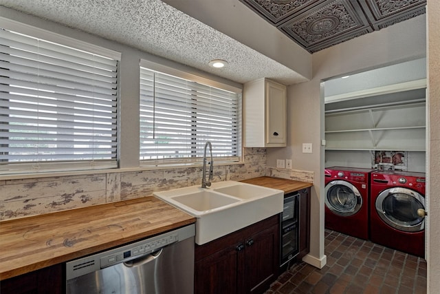 1437 Bowsprit Pt, Willis, TX 77318 - kitchen with wooden counters, stainless steel dishwasher, independent washer and dryer, and brick floors